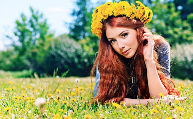 Romantic young woman in a circlet of flowers outdoors.